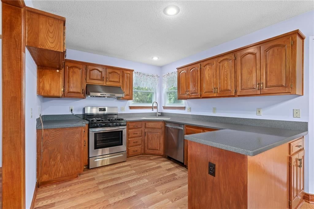 Gas range, stainless steel appliances and wood kitchen cabinets at 7702 W 155th Street, Overland Park, KS 66223