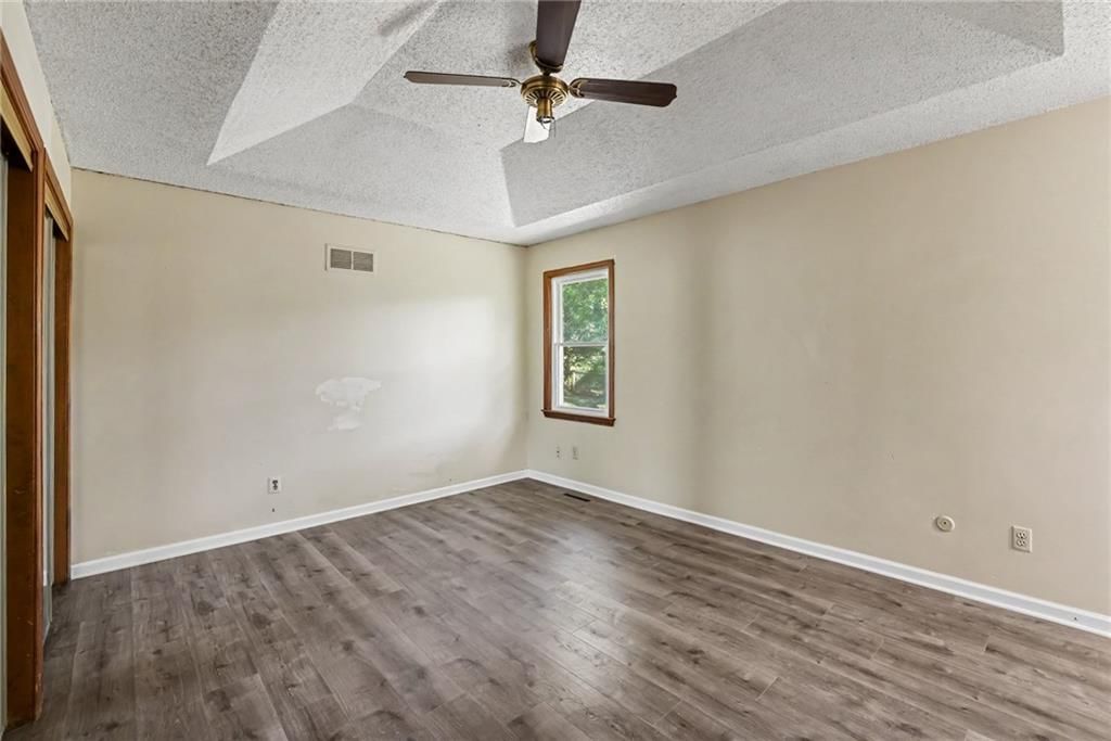 Main-floor primary bedroom and tray ceiling at 13935 S Cottonwood Drive, Olathe, KS 66062