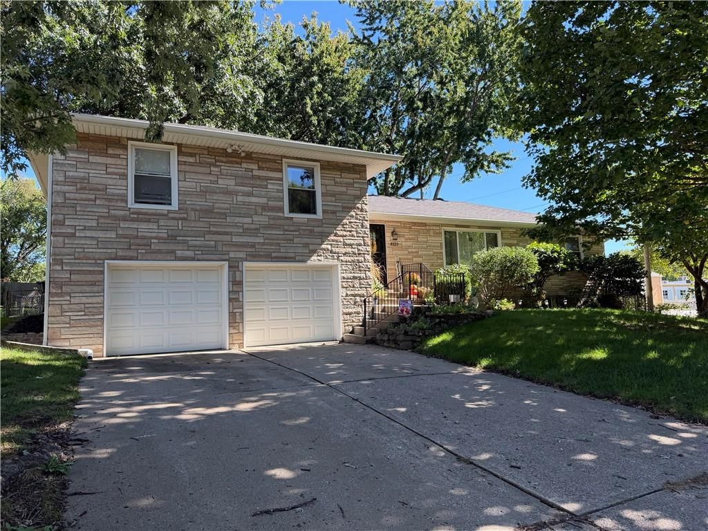 Stone exterior, mature trees and attached garage at 4121 N Briarcliff Road, Kansas City, MO 64116