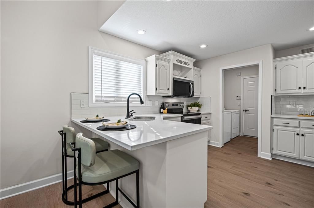 Kitchen island, white kitchen and updated kitchen at 510 NW Ashurst Place, Lee's Summit, MO 64081