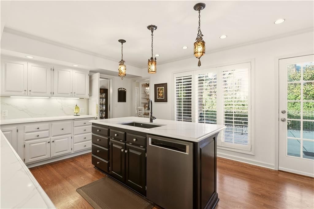 Open floor plan, kitchen island and white kitchen at 1010 W 65th Street, Kansas City, MO 64113