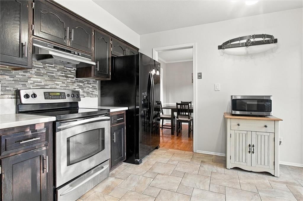 Stainless steel appliances, electric range and staircase at 13929 S Summertree Lane, Olathe, KS 66062