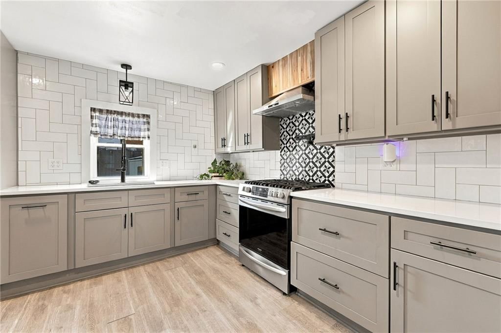 Gas range, gray kitchen cabinets and shaker cabinets at 2638 Jarboe Street, Kansas City, MO 64108