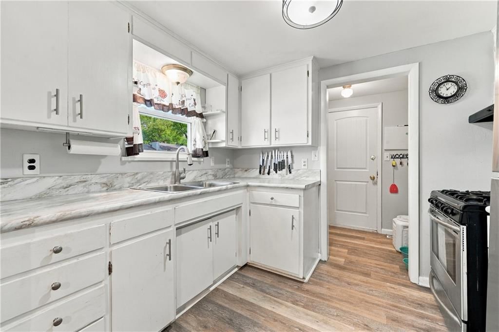 White kitchen and veined countertops at 1009 E 134th Street, Grandview, MO 64030