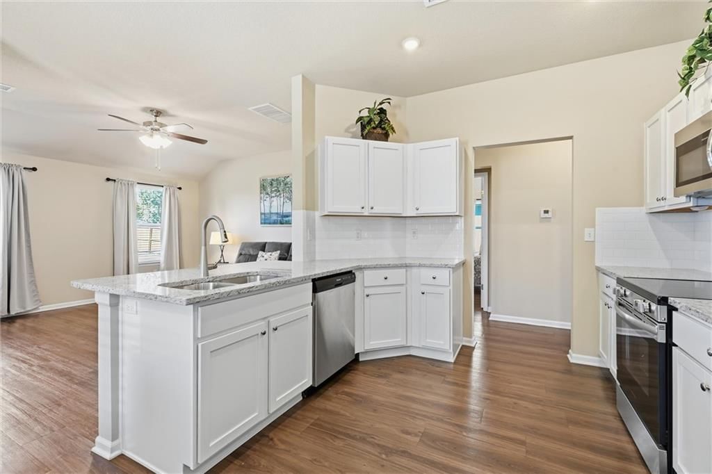 White kitchen, granite counters and stainless steel appliances at 526 N Pear Street, Gardner, KS 66030