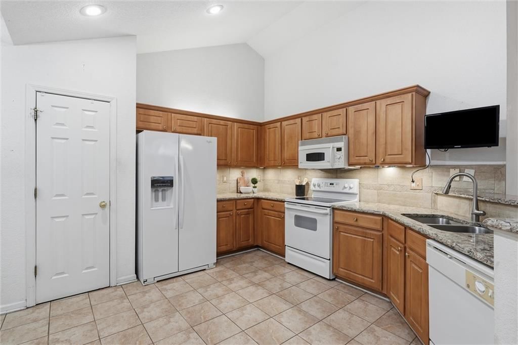 Granite counters, tile floors and wood kitchen cabinets at 6122 NE KENSINGTON Drive, Lee's Summit, MO 64064