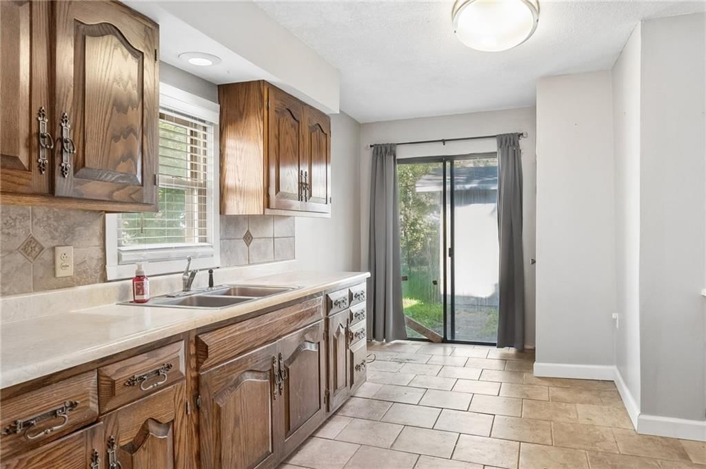 Tile floors, wood kitchen cabinets and kitchen backsplash at 3002 W 44th Avenue, Kansas City, KS 66103