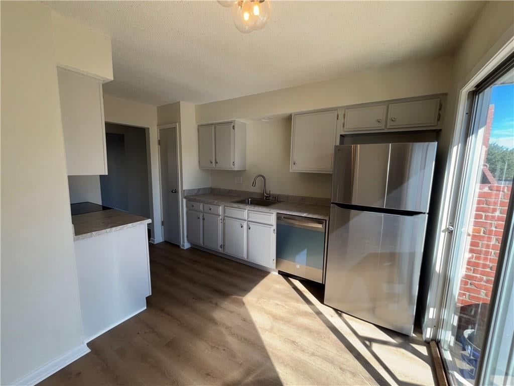 White kitchen, stainless steel appliances and gray countertops at 11261 Calico Drive, Kansas City, MO 64137