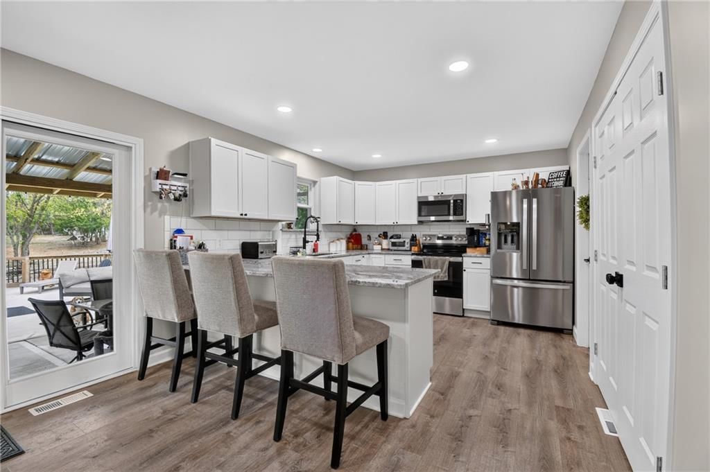 Kitchen island, white kitchen and granite counters at 18902 E 263rd Street, Harrisonville, MO 64701