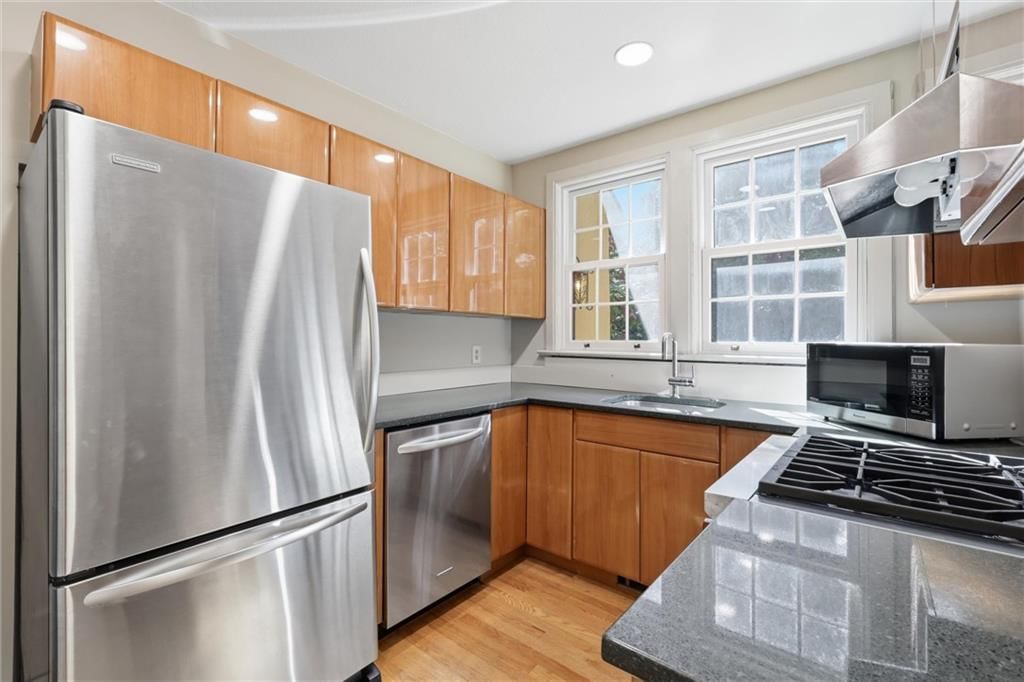 Stainless steel appliances, wood kitchen cabinets and kitchen backsplash at 2017 W 50th Street, Westwood Hills, KS 66205