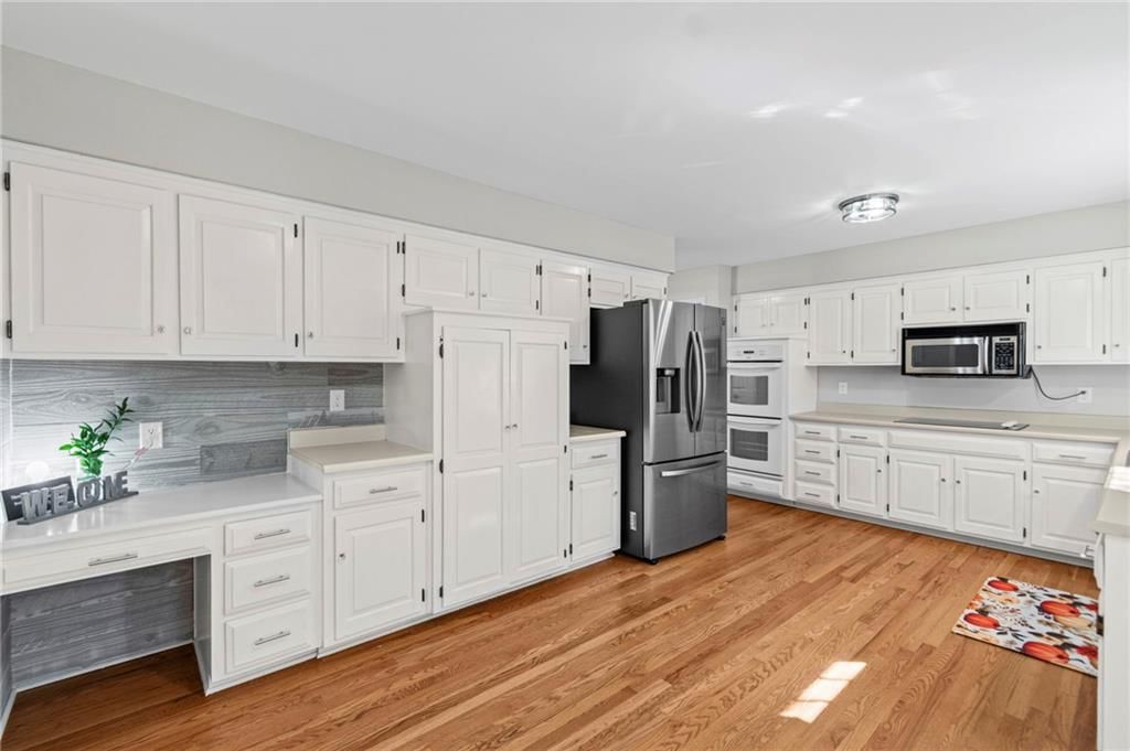 White kitchen, double oven and stainless steel appliances at 11278 Hemlock Street, Overland Park, KS 66210