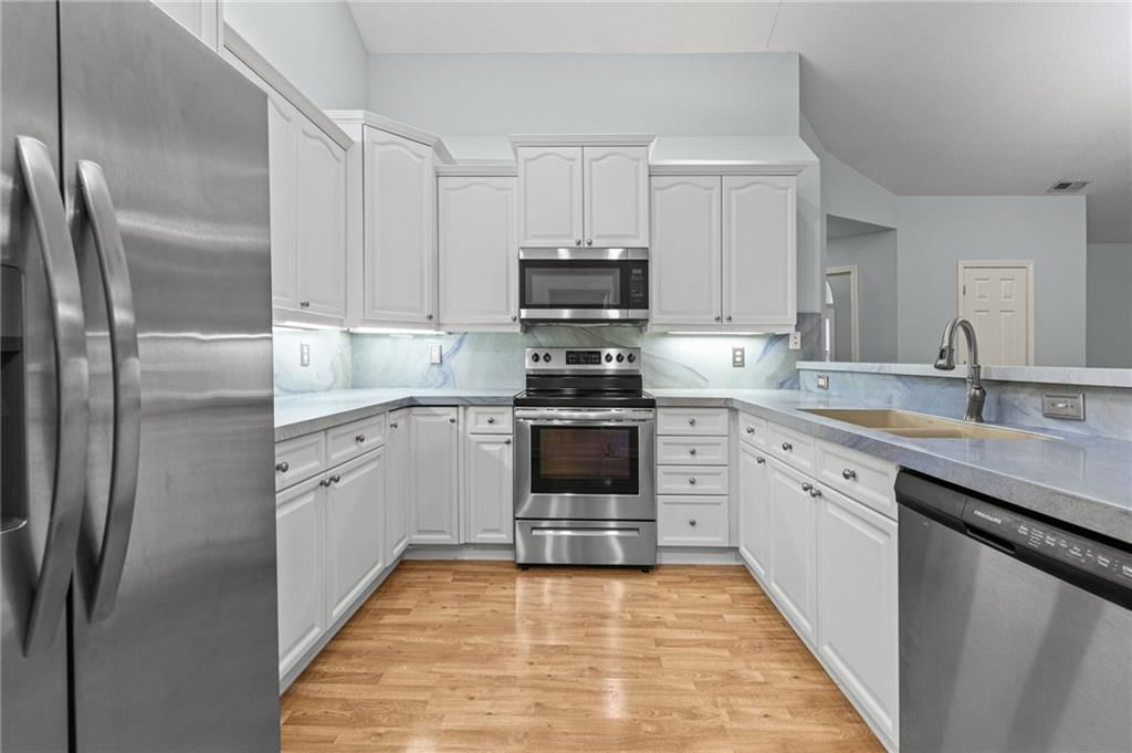 White kitchen, stainless steel appliances and electric range at 7110 Hedge Lane Terrace, Shawnee, KS 66227