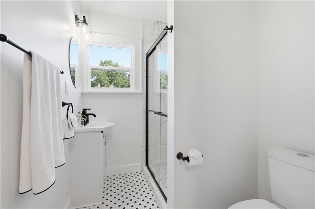 Tiled shower, frameless glass shower and black hardware at 6101 Charlotte Street, Kansas City, MO 64110