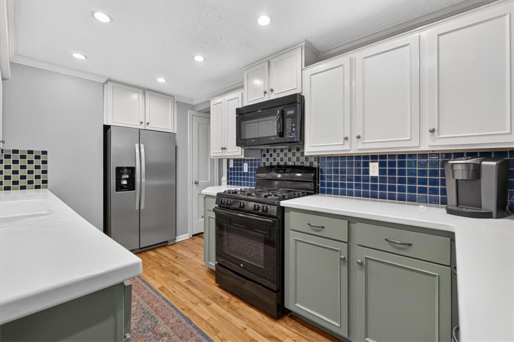 Gas range, two-tone kitchen cabinets and shaker cabinets at 4112 W 69TH Street, Prairie Village, KS 66208