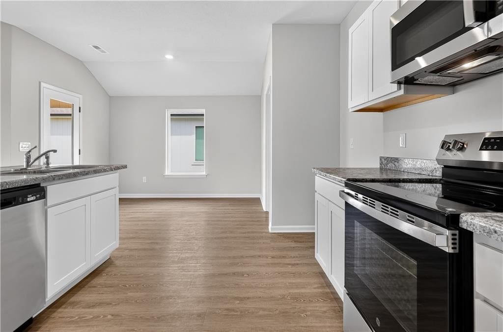 Open floor plan, white kitchen and stainless steel appliances at 757 N Buckeye Street, Gardner, KS 66030