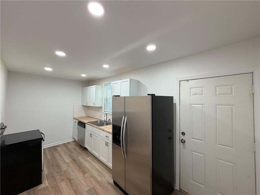 White kitchen, butcher block countertops and stainless steel appliances at 5026 E 7th Street, Kansas City, MO 64124
