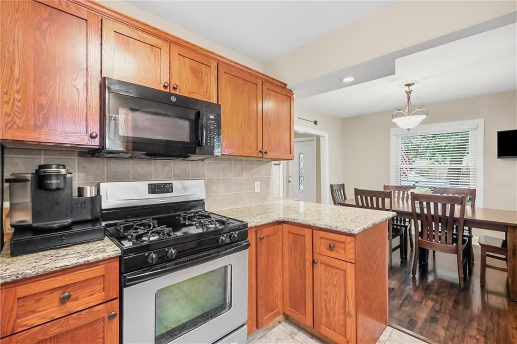 Granite counters, gas range and wood kitchen cabinets at 5127 Walnut Street, Kansas City, MO 64112