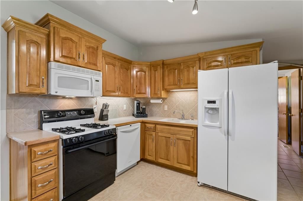 Gas range, tile floors and wood kitchen cabinets at 18510 E 5th Street N, Independence, MO 64056