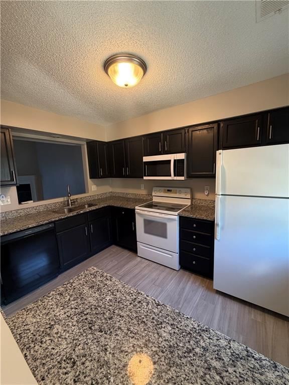 Granite counters, black kitchen cabinets and white appliances at 725 SW Liggett Road #C, Blue Springs, MO 64015