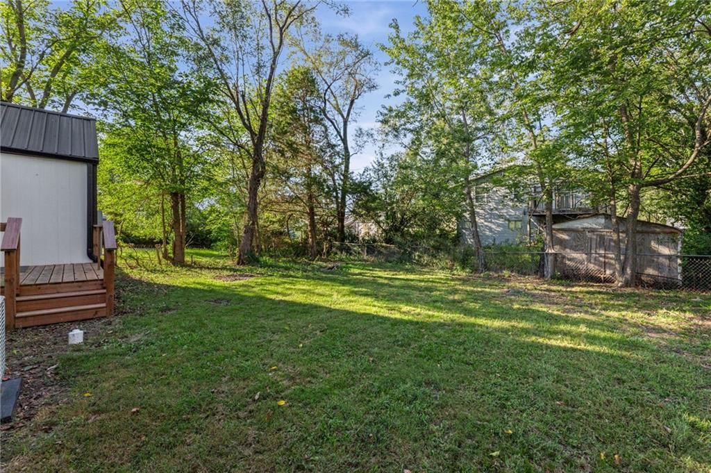 Deck, fenced yard and mature trees at 1734 Main Street, Osawatomie, KS 66064