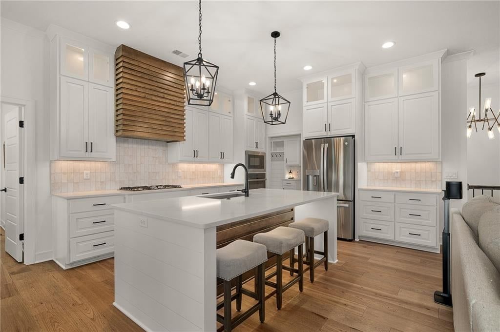 Kitchen island, white kitchen and quartz counters at 4209 NE Hideaway Drive, Lee's Summit, MO 64064