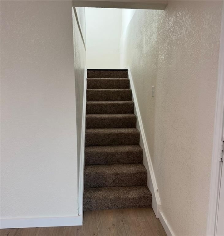 Staircase, wood stair railing and carpet at 8409 Curly Lane, Freeman, MO 64746