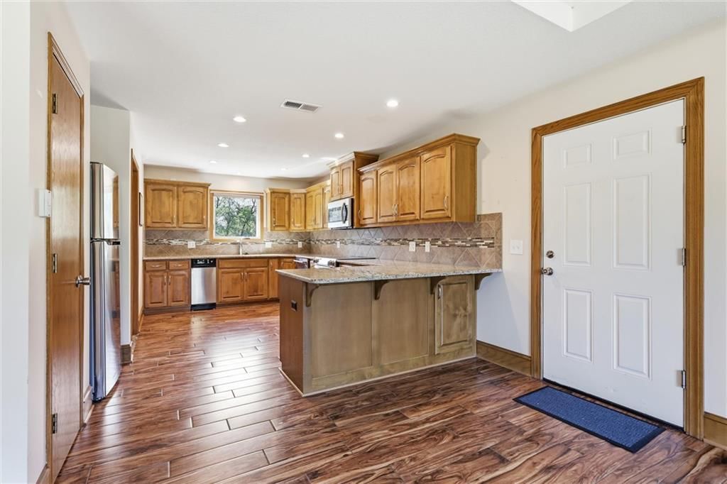 Kitchen island, granite counters and stainless steel appliances at 7000 Fort Myers Boulevard, Belton, MO 64012
