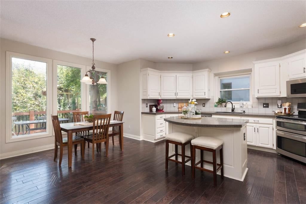 Open floor plan, kitchen island and white kitchen at 11305 W 144 Street, Overland Park, KS 66221