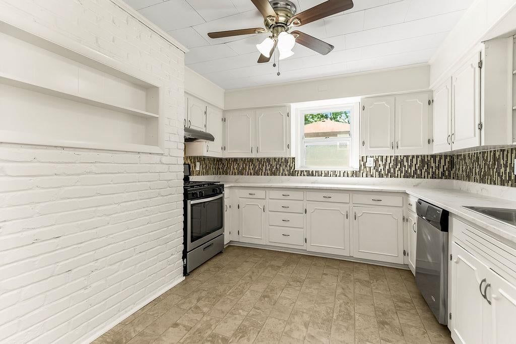 White kitchen, gas range and stainless steel appliances at 16000 Allen Avenue, Belton, MO 64012