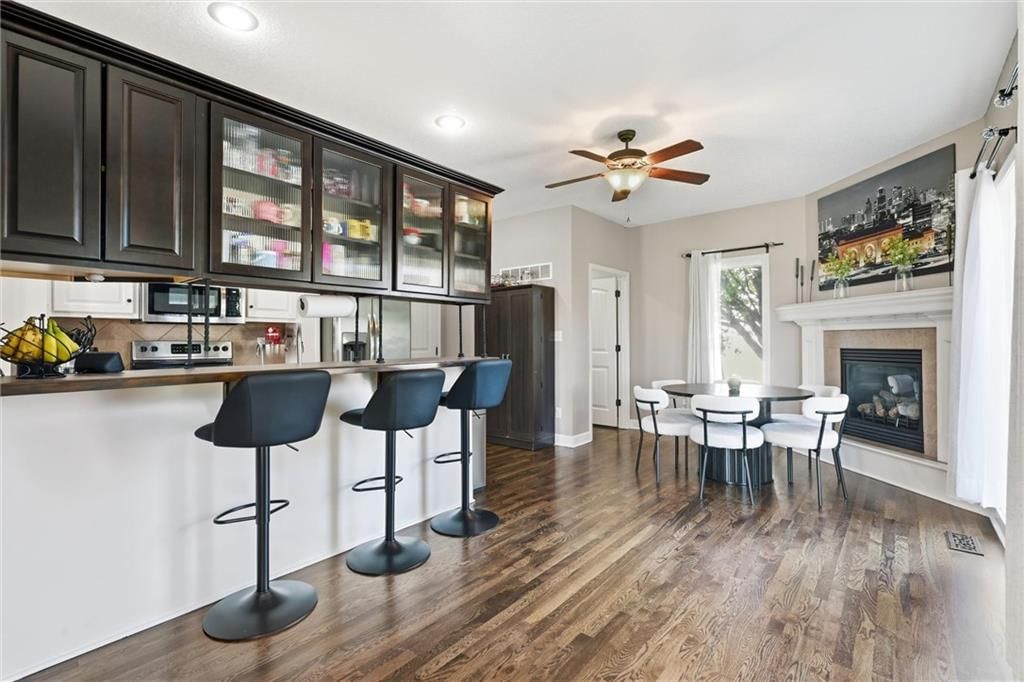 Kitchen island, granite counters and two-tone kitchen cabinets at 16917 Cross Creek Drive, Belton, MO 64012