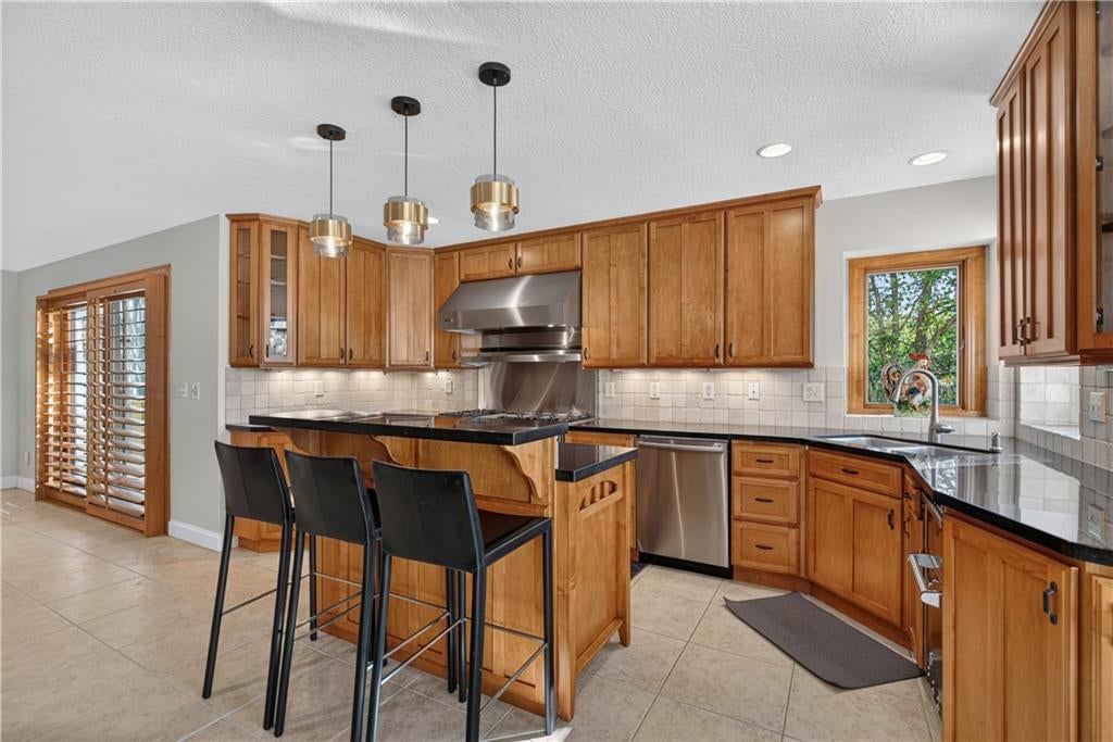 Kitchen island, high end appliances and stainless steel appliances at 118 NE Edgewater Drive, Lee's Summit, MO 64064