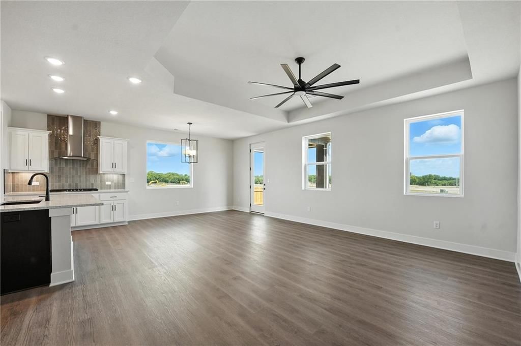 Kitchen island, white kitchen and gas range at 20579 Barker Street, Spring Hill, KS 66083