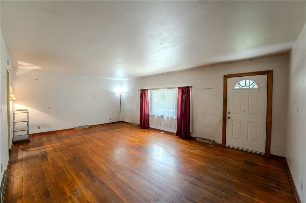 Main-floor primary bedroom and hardwood floors at 1135 S 55th Street, Kansas City, KS 66007