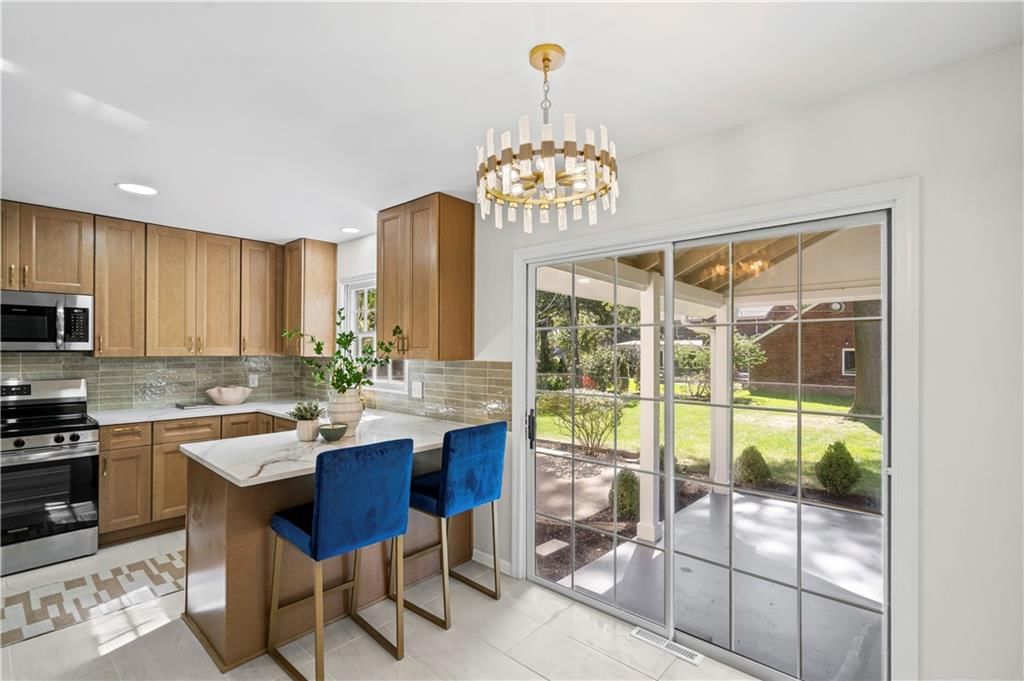 Kitchen island, statement lighting and breakfast nook at 5419 W 100th Terrace, Overland Park, KS 66207