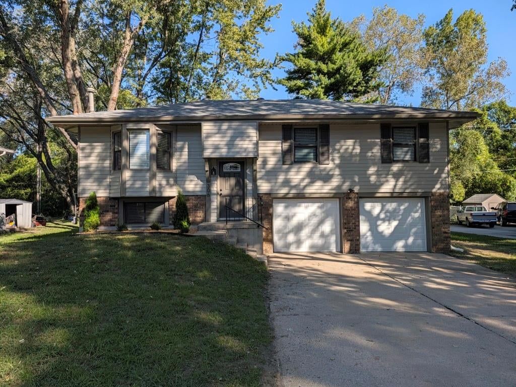 Corner lot, mature trees and attached garage at 306 SE 21st Street, Oak Grove, MO 64075