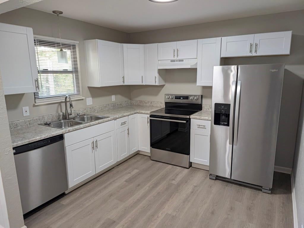 White kitchen, granite counters and shaker cabinets at 306 SE 21st Street, Oak Grove, MO 64075