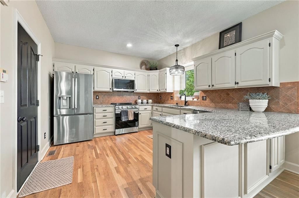 Kitchen island, kitchen backsplash and black hardware at 15836 W 153rd Terrace, Olathe, KS 66062