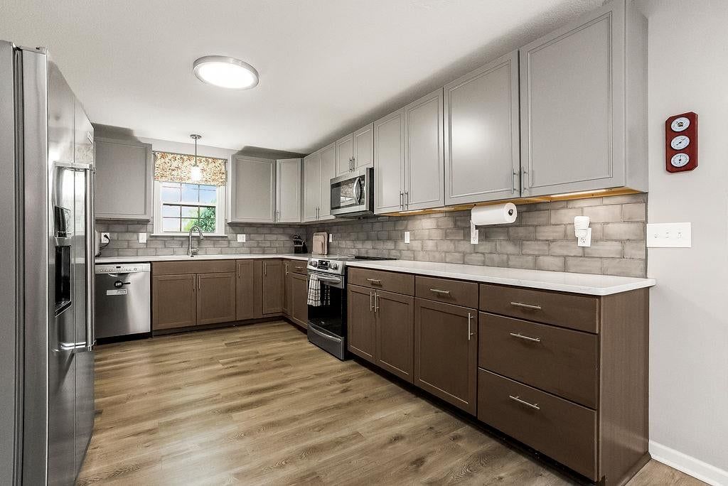 Two-tone kitchen cabinets, stainless steel appliances and electric range at 1107 ELM Circle, Pleasant Hill, MO 64080