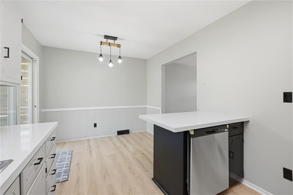 Open floor plan, kitchen island and white kitchen at 205 SW Kingscross Road, Blue Springs, MO 64014