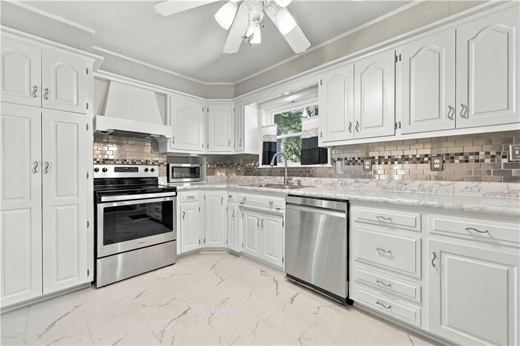 White kitchen and stainless steel appliances at 12004 E 48th Street S, Kansas City, MO 64133