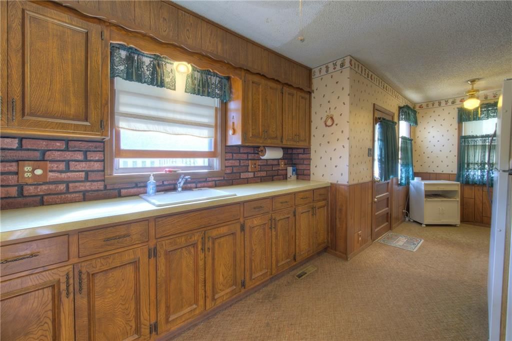 Exposed brick wall, wood kitchen cabinets and kitchen backsplash at 3003 Ruby Avenue, Kansas City, KS 66106