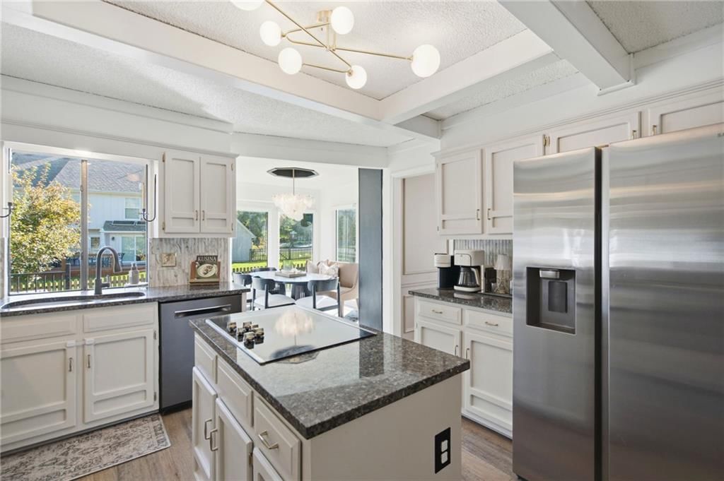 Open floor plan, kitchen island and white kitchen at 206 NE Shoreview Drive, Lee's Summit, MO 64064