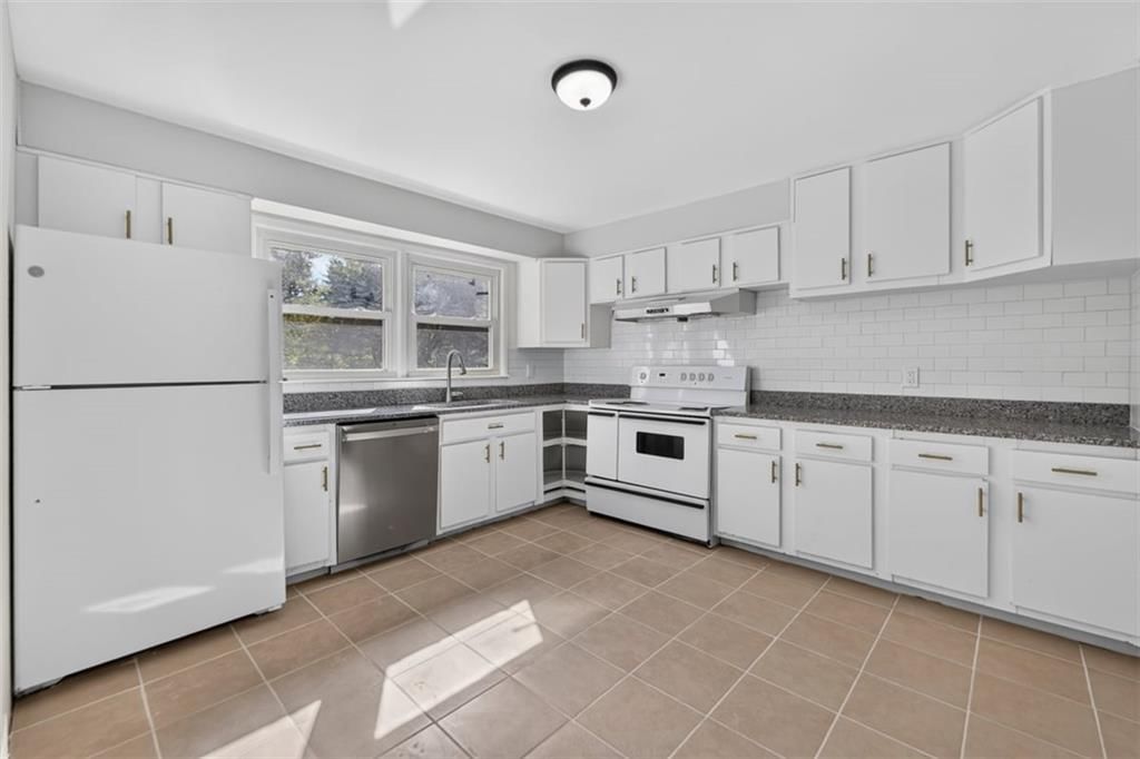 White kitchen, white appliances and electric range at 3211 Berry Road, Kansas City, KS 66106