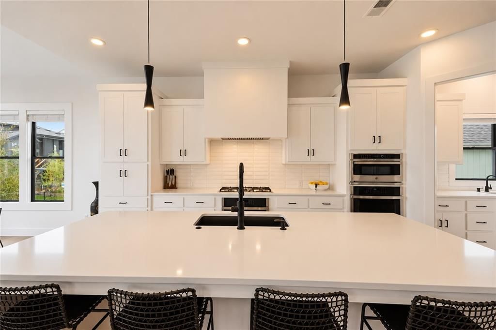 Kitchen island, white kitchen and quartz counters at 12602 W 169 Terrace, Overland Park, KS 66221