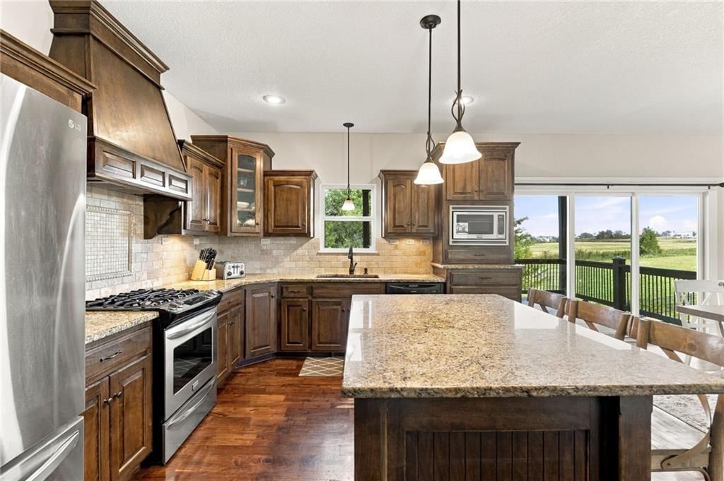 Kitchen island, granite counters and gas range at 17700 NW 130th Terrace, Platte City, MO 64079