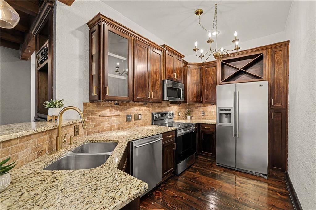 Statement lighting, stainless steel appliances and wood kitchen cabinets at 1111 46th Street W #22, Kansas City, MO 64112