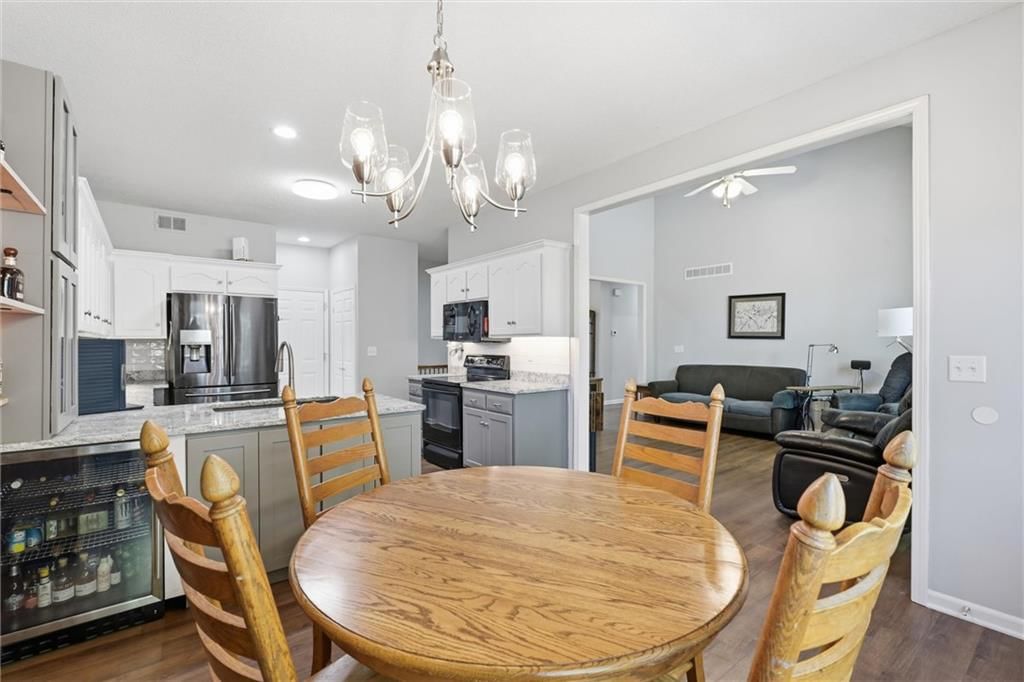 Kitchen island, granite counters and two-tone kitchen cabinets at 20426 W 220th Terrace, Spring Hill, KS 66083