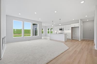 Open floor plan, kitchen island and white kitchen at 1600 SW 9th Street, Oak Grove, MO 64075