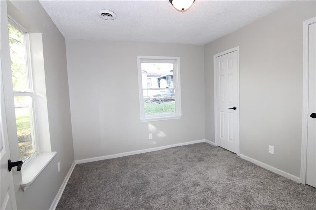 Main-floor primary bedroom, black hardware and carpet at 5638 Miami Avenue, Kansas City, KS 66106