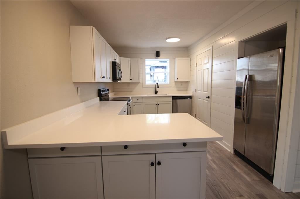 Shiplap / paneling, stainless steel appliances and white countertops at 5638 Miami Avenue, Kansas City, KS 66106